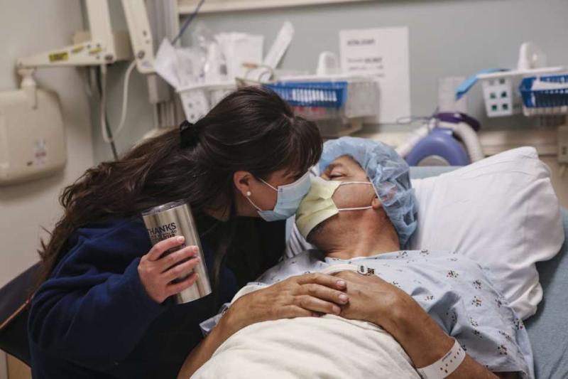 A transplant donor recipient gives a parting kiss to his wife before surgery.