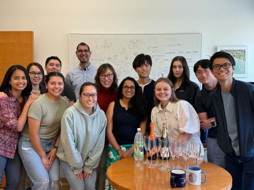 A group of researchers stand smiling in a UCLA office.
