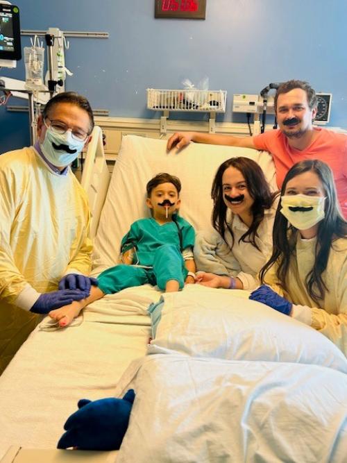 Jakob Guziak, family, and Dr. Kohn in a hospital room.