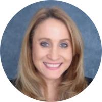 Professional headshot of a woman with blonde hair smiling against a blue background