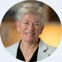 headshot of aileen anderson wearing a grey suit and black top