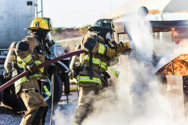 Two firefighters put out a blaze.