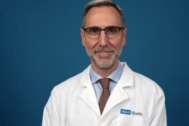 Dr. Antoni Ribas wears a labcoat and smiles for a headshot.