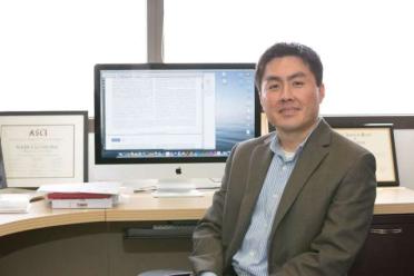 Dr. Roger Lo pictured seated at his desk. 