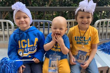 Three young siblings don UCLA gear.