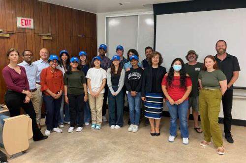 A group of physiology outreach program students stand in a UCLA classroom.