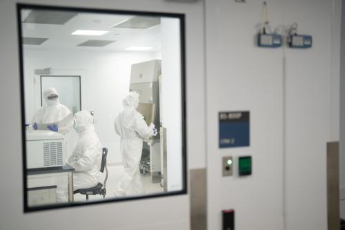 Three scientists clad in all-white "bunny" protective suits work inside the UCLA Center for Advanced Biotherapies.