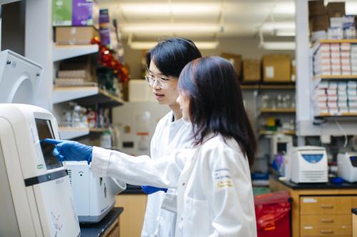 Two scientists looking at a machine in a lab