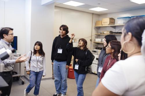 high school students in the microscopy core passing around a cell slide