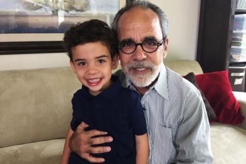 A photograph of a smiling grandfather and his grandson.