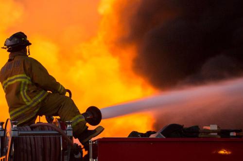 A firefighter can be observed hosing a blaze. 
