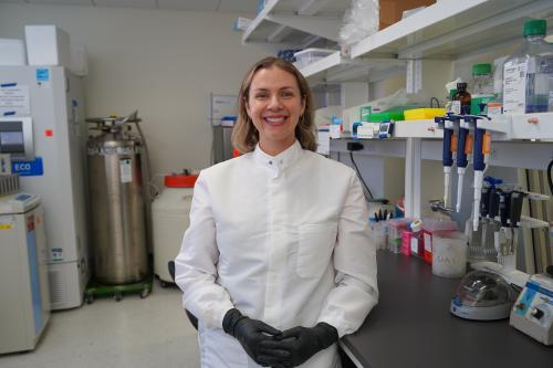 Dr. Amy Vandiver stands smiling in her UCLA lab.
