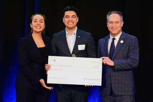 Noor Nakhaei, Pablo Alvarez, and Brian Kite pose with a large ceremonial check at the UCLA Grad Slam event.