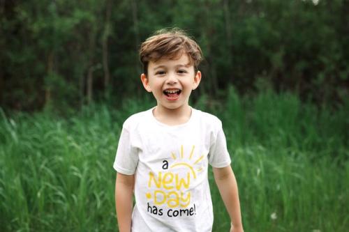 Jakob Guziak smiles in a grassy field.