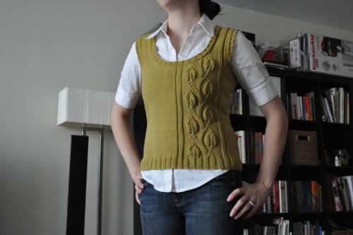woman wearing a white shirt with a green knitted vest over