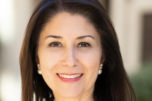 Headshot of Sanaz Memarzadeh. She is smiling and wearing a grey blazer.