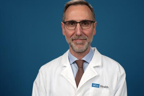Dr. Antoni Ribas wears a labcoat and smiles for a headshot.