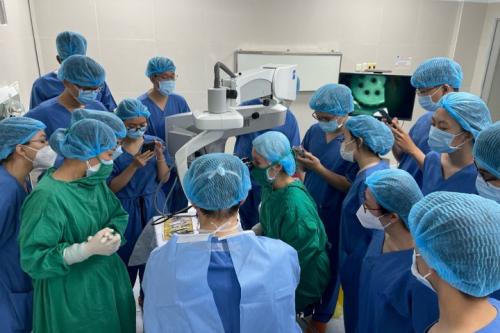 A group of ophthalmologists huddles together for a skill transfer session with Dr. Anthony Aldave.