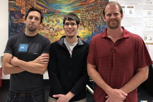A photo of three UCLA-affiliated individuals standing and smiling side-by-side in front of a colorful mural. From left to right: Manuel Rosa-Garrido, postdoctoral fellow; Douglas Chapski, graduate student; and Thomas Vondriska, UCLA professor of anesthesiology, medicine and physiology.