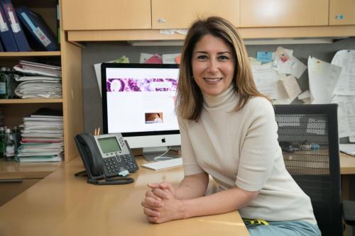 A UCLA researcher smiles in her office. 