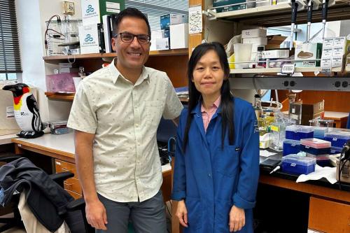 Two scientists stand at a lab bench at UCLA
