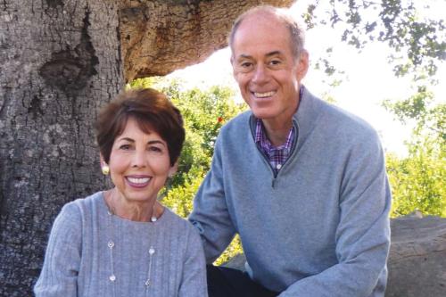 Connie Frank and Evan Thompson shown smiling outdoors.