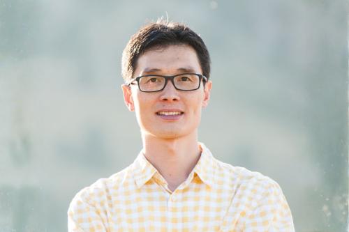 Headshot of Rui Yi in a light yellow checkered button up and glasses