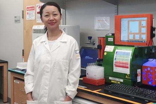 Headshot of Lili Yang in the lab in front of lab equipment