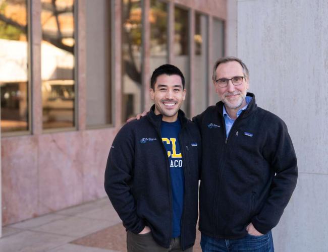 Two UCLA scientists smile together outdoors.