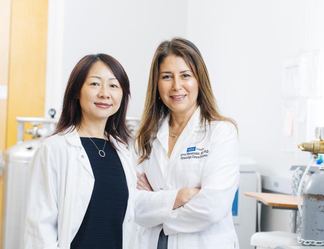 Dr. Lili Yang and Dr. Sanaz Memarzadeh smile next to one another in a UCLA lab.