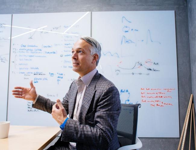 Alexander Hoffman gestures animatedly in a UCLA working space.