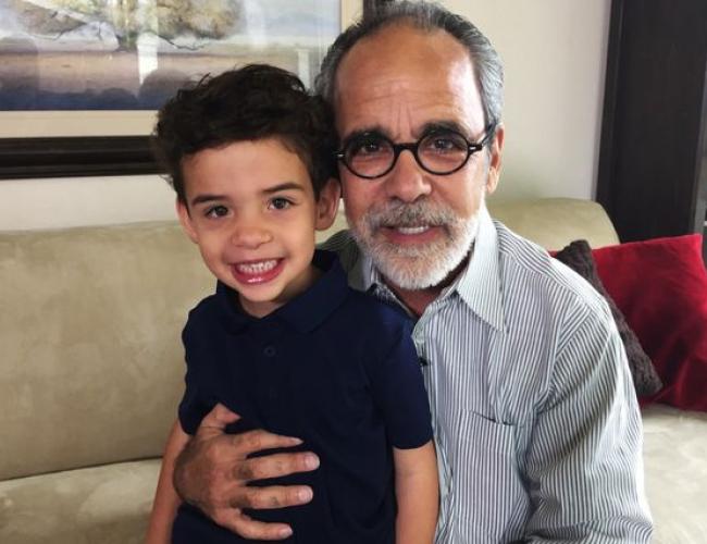A photograph of a smiling grandfather and his grandson.