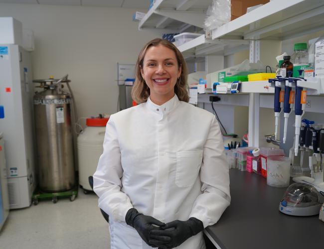 Dr. Amy Vandiver stands smiling in her UCLA lab.