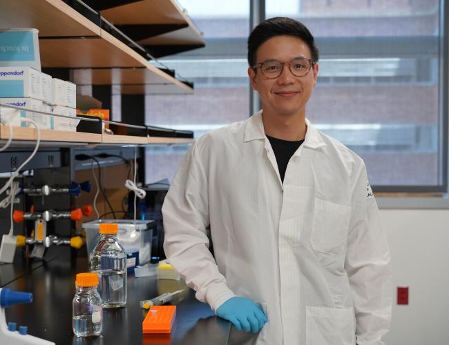 Dr. Chen Yuan Kam, posing in front of his laboratory.