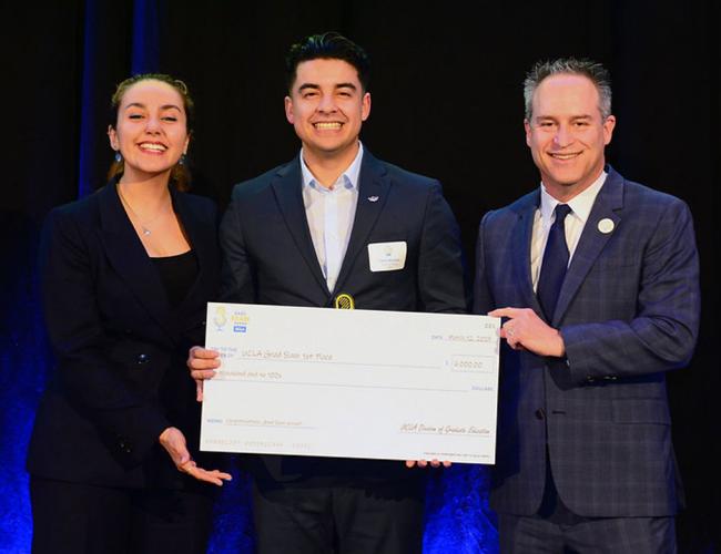 Noor Nakhaei, Pablo Alvarez, and Brian Kite pose with a large ceremonial check at the UCLA Grad Slam event.