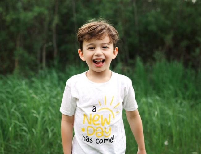 Jakob Guziak smiles in a grassy field.