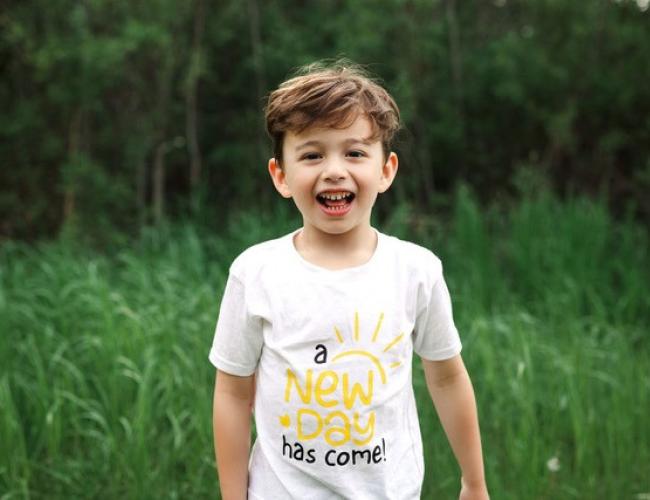 Jakob Guziak smiles in a grassy field.