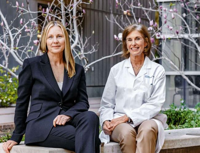 Amander Clark and Beth Karlan seated on a UCLA bench.