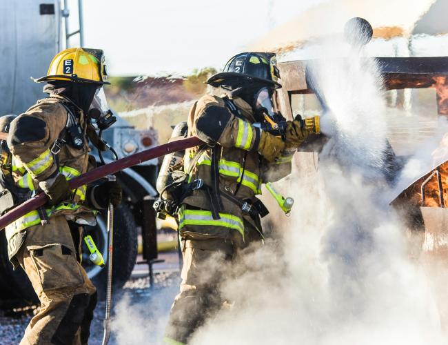 Two firefighters put out a blaze.
