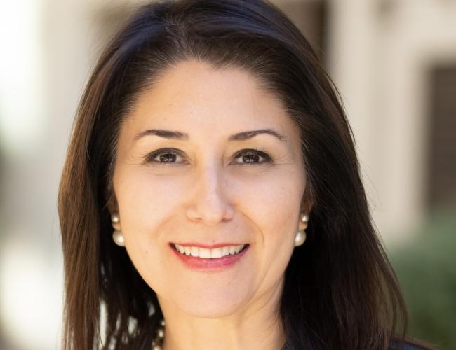 Headshot of Sanaz Memarzadeh. She is smiling and wearing a grey blazer.