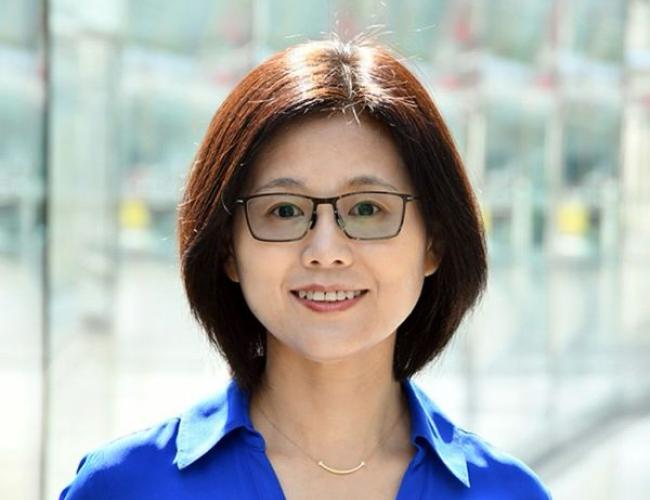 A headshot of Dr. Meng Wang, the speaker for the Metabolic Signals in Longevity Regulations Across Scales seminar. Dr. Wang is pictured smiling, and is wearing a blue blouse and glasses.