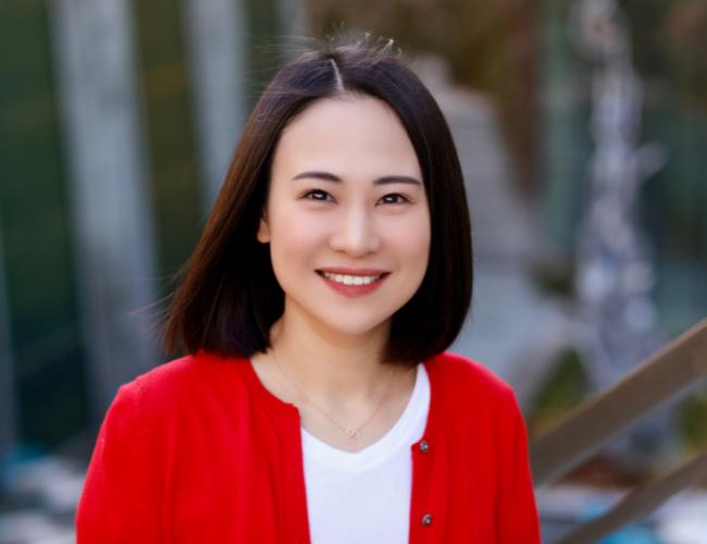 headshot of scientist mingxia gu wearing a white shirt and red cardigan