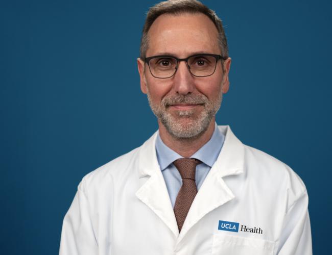 Dr. Antoni Ribas wears a labcoat and smiles for a headshot.