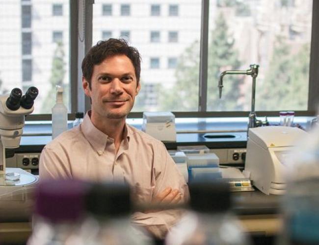 Patrick Allard stands smiling in a laboratory. 