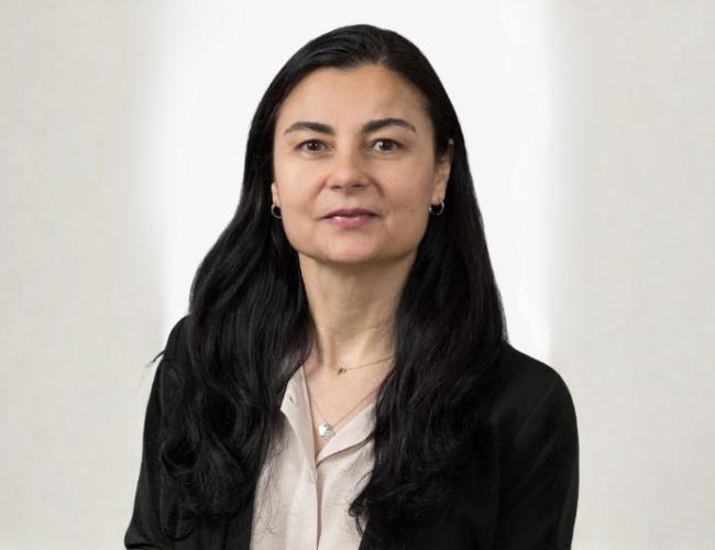 Headshot of Roxana Radu wearing a dark blazer and light button up shirt