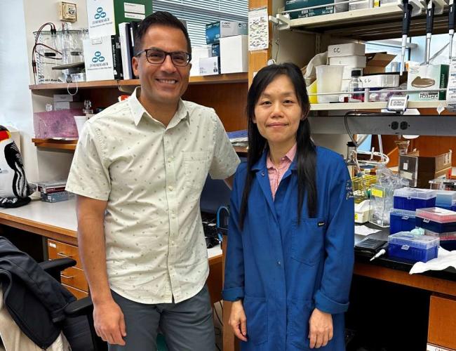 Two scientists stand at a lab bench at UCLA