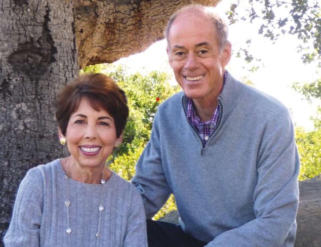 Connie Frank and Evan Thompson shown smiling outdoors.
