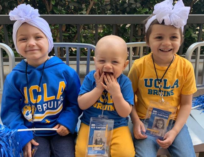 Three young siblings don UCLA gear.