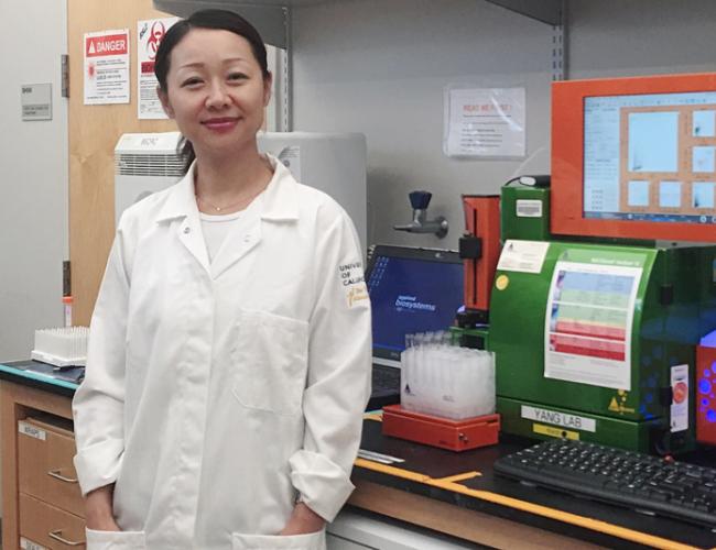 Headshot of Lili Yang in the lab in front of lab equipment