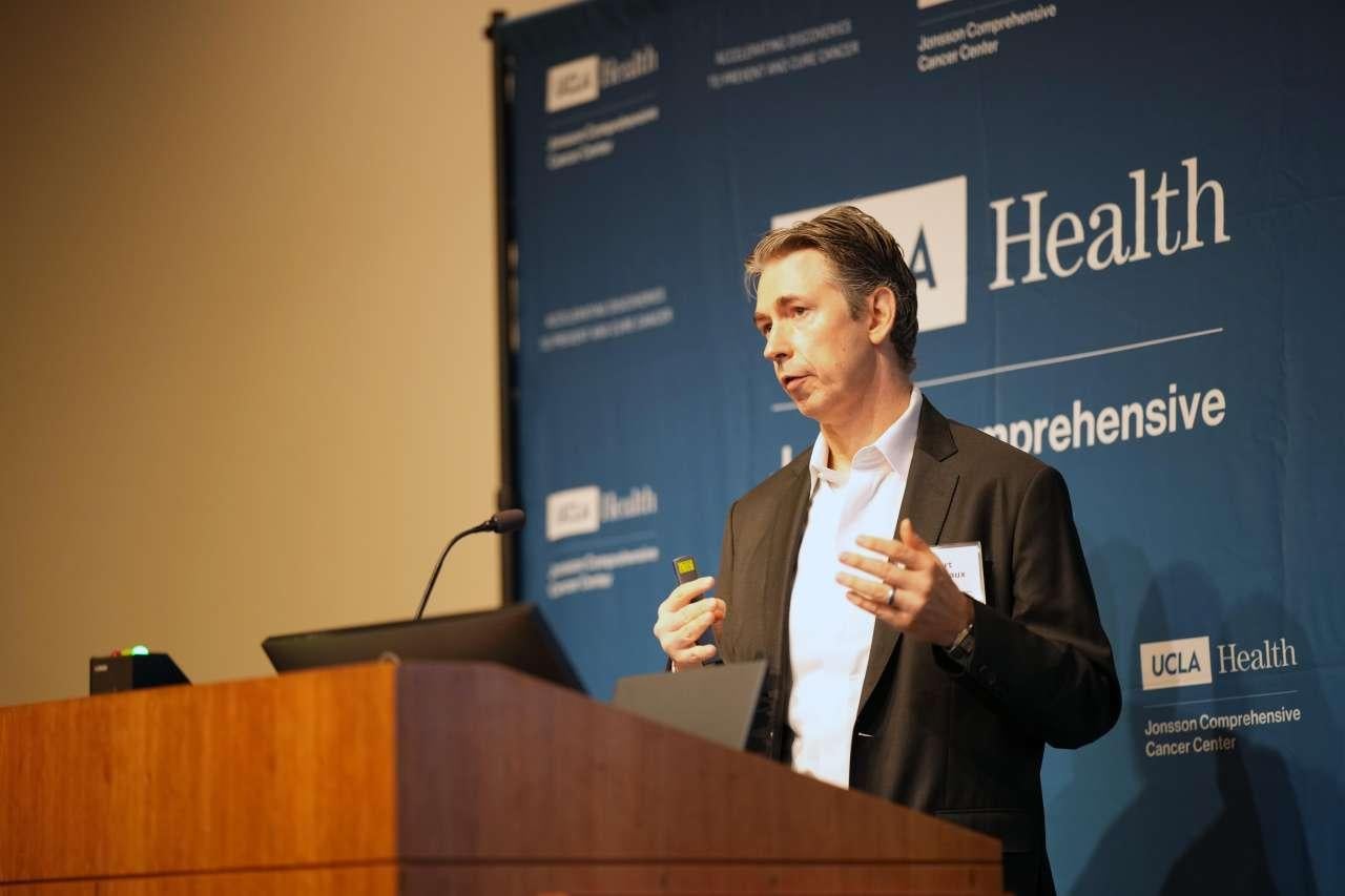 UCLA scientist Robert Damoiseaux speaks at a podium.